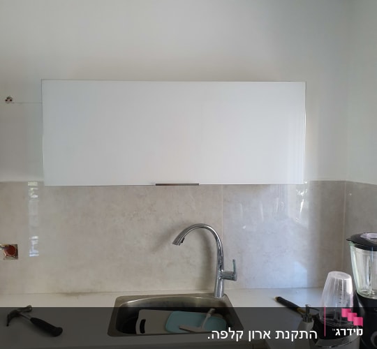 כיור מטבח עם קרש חיתוך, בלנדר וכלים
